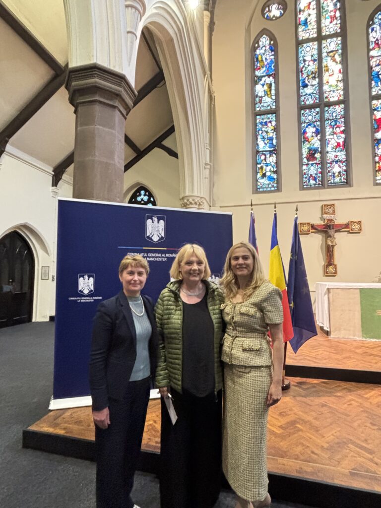 Dina Railean, Honorary Consul of the Republic of Moldova in Manchester, is pictured with Nicoleta Teodorovici and acclaimed Romanian actress Emilia Popescu following the cultural event "Aplauze pentru Poet" on 9 June 2026. The photograph was taken at the venue hosted by the Consulate General of Romania in Manchester, with the Romanian, European Union and diplomatic flags displayed behind them. The gathering celebrated Romanian poetry, language and cultural heritage through a performance by Emilia Popescu and pianist Cătălin Răducanu, highlighting the role of cultural diplomacy in strengthening ties between the Republic of Moldova, Romania and the United Kingdom.