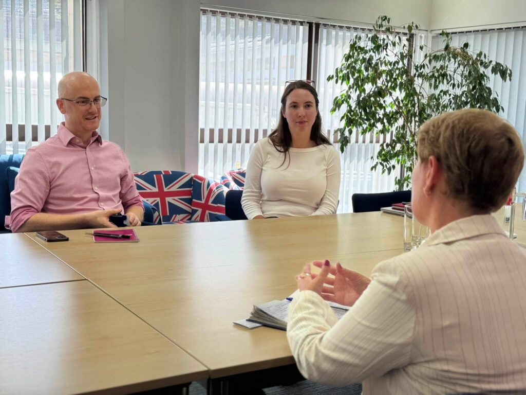 Dina Railean, Honorary Consul of the Republic of Moldova in Manchester, meets Robert “Bob” Easton, Deputy Head of Mission, and a British Embassy colleague at the British Embassy in Chisinau on 19 August 2026 to discuss UK-Moldova cooperation. Union Jack cushions appear in the background.
