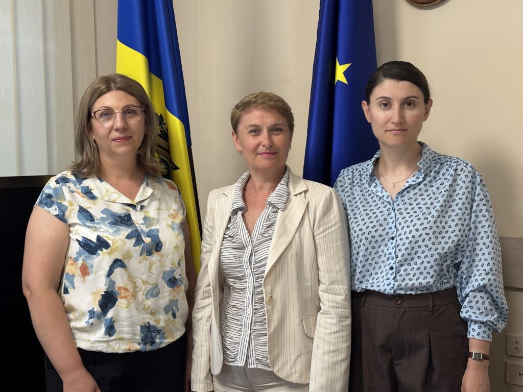 Dina Railean, Honorary Consul of the Republic of Moldova in Manchester, Violina Donu and Oxana Rosca at the Office for Diaspora Relations in the Government Building in Chisinau on 19 August 2026. The Moldovan and European Union flags appear behind them.