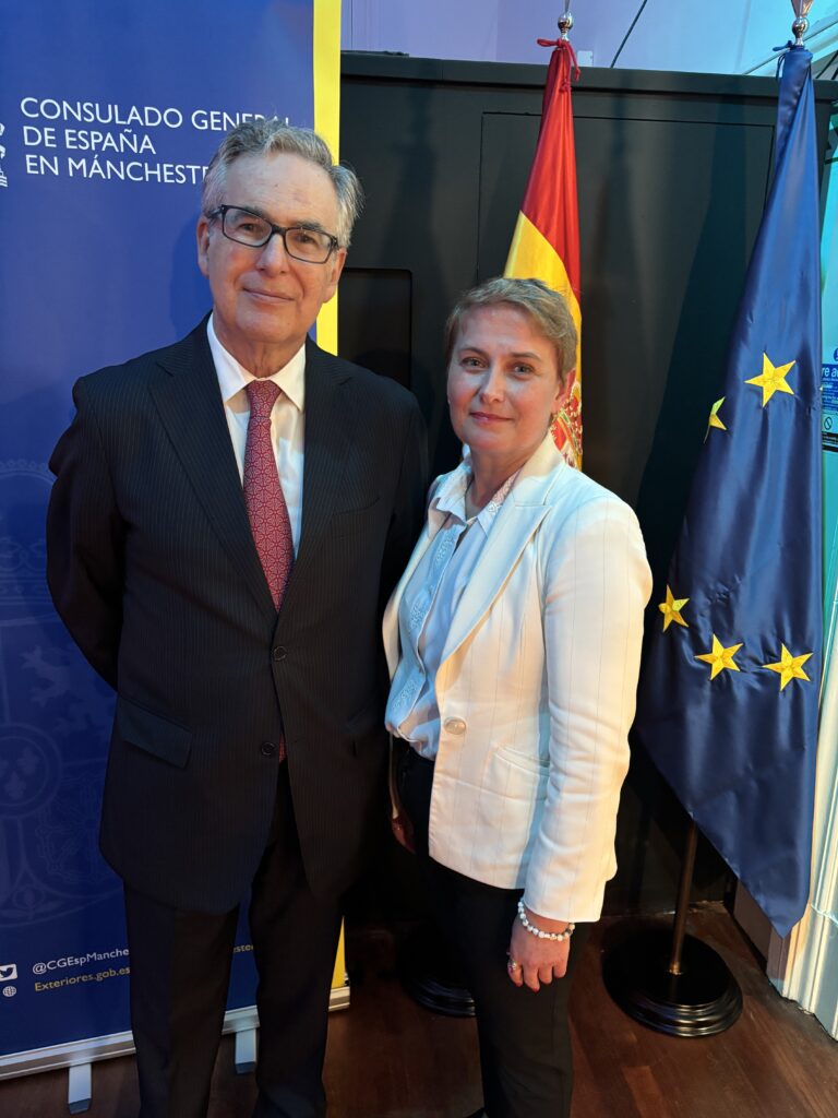 Alejandro Polanco Mata, Consul General of Spain in Manchester, with Dina Railean, Honorary Consul of the Republic of Moldova in Manchester, at Spain’s National Day celebration at Instituto Cervantes Manchester on 14 October 2026. The Spanish and European Union flags and Consulate General of Spain display appear behind them.